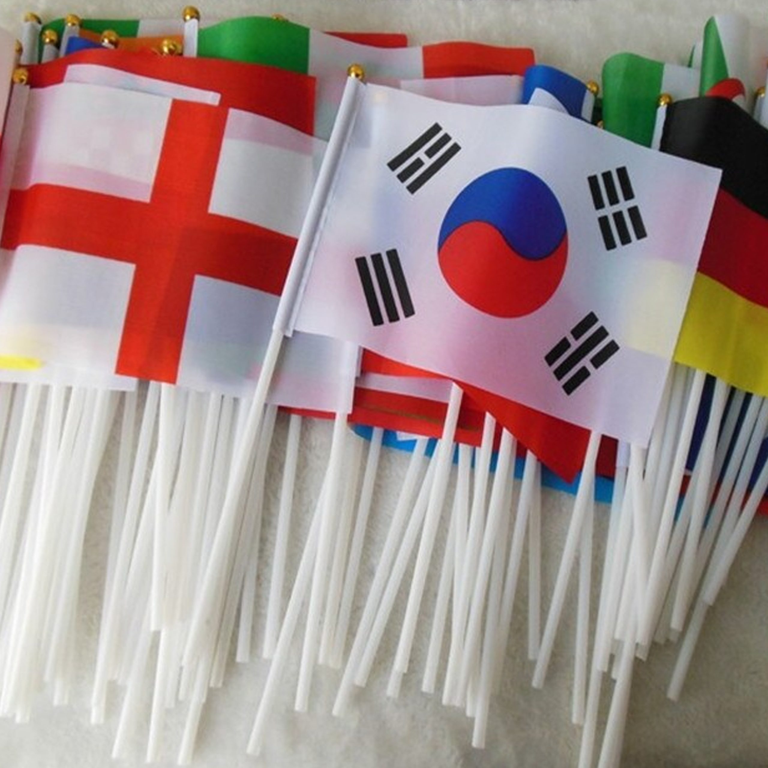 A collection of colorful handheld flags representing various countries, displayed together in a vibrant arrangement.