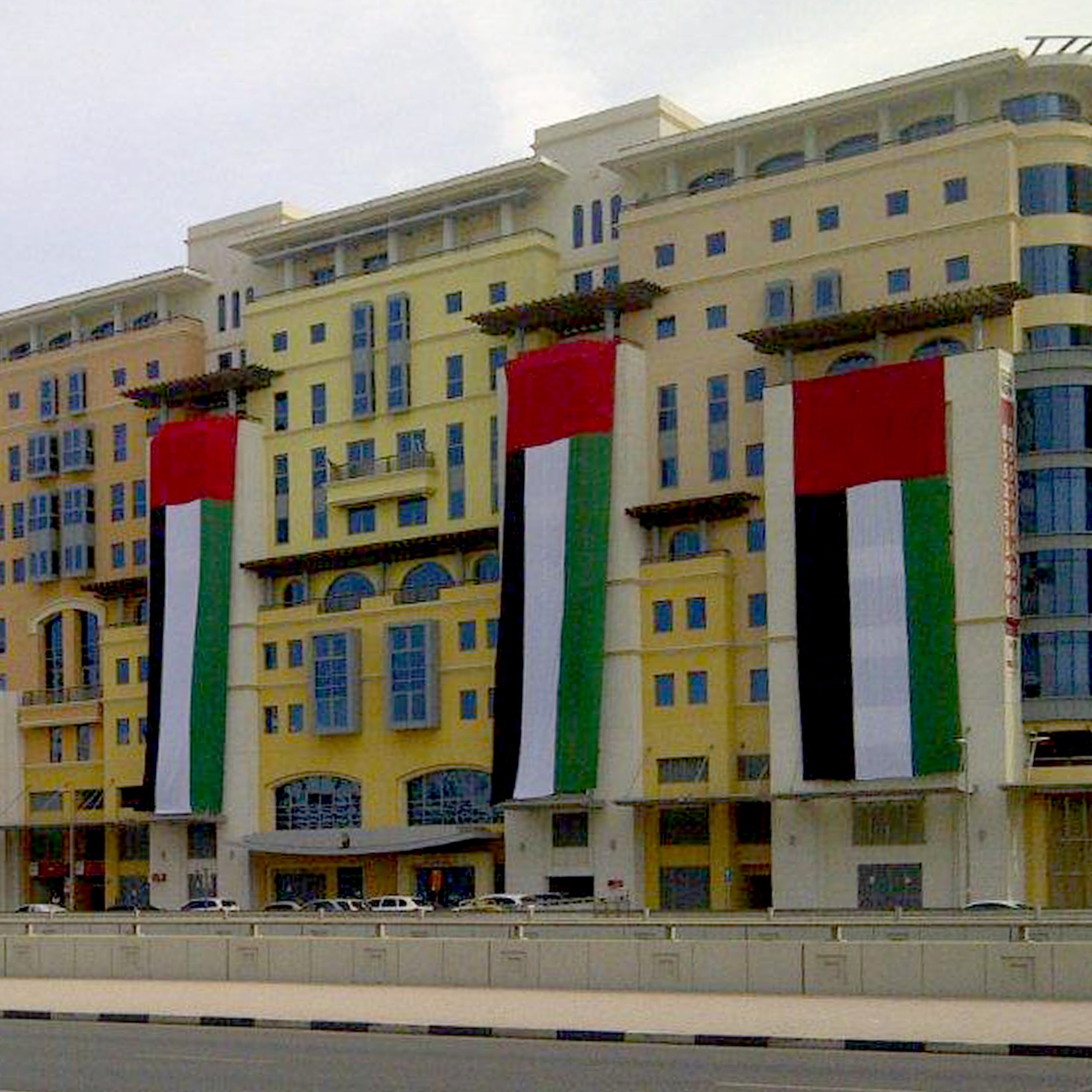 A multi-flagged building, featuring a variety of large flags 