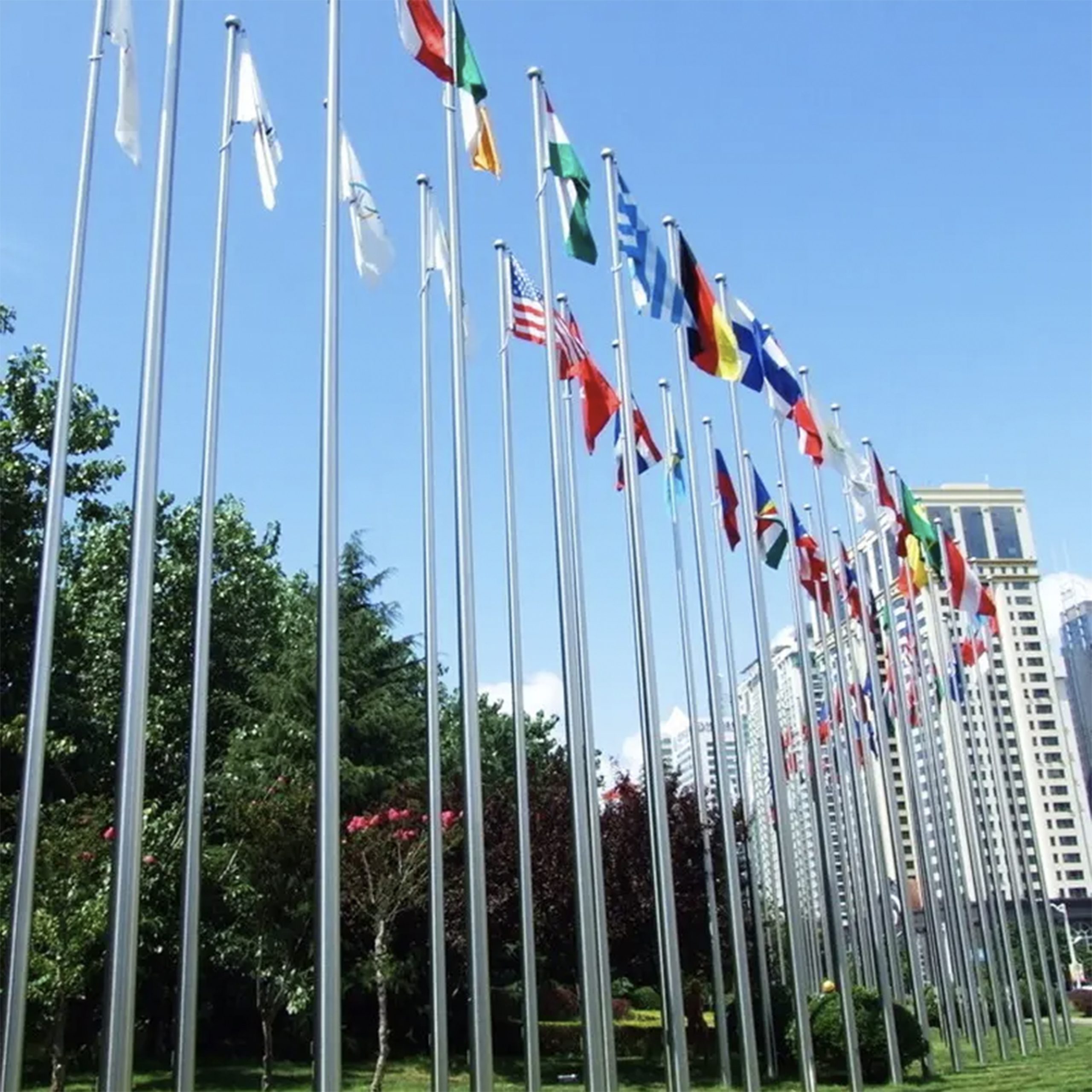 Multiple fibre glass pole flags arranged in a straight line, each featuring unique patterns and vibrant colors